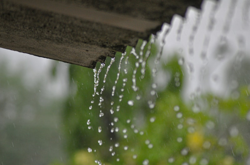 Water running through a rain gutter during a heavy storm showing active water flow and the importance of proper flashing to direct rainfall