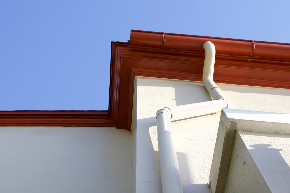 Gutter system mounted on the side of a residential building showing the exterior gutter edge where splash guards attach