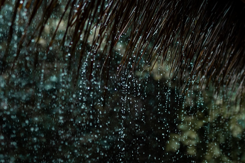 Heavy rain falling off a roof edge during an intense downpour, illustrating the high water volume Sacramento gutters must handle during atmospheric river storms