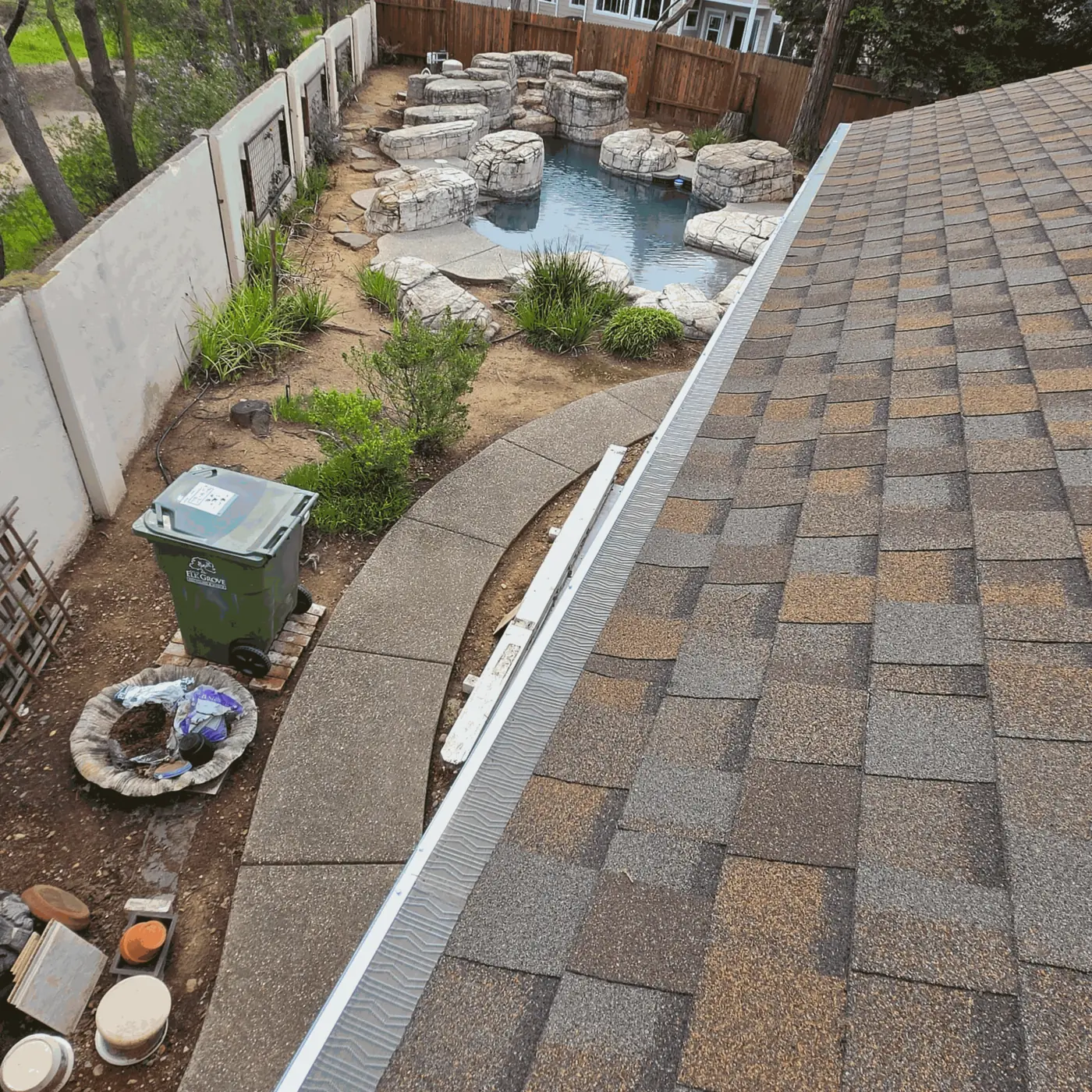Micro-mesh gutter guard on a shingle roof above a backyard pool in Elk Grove